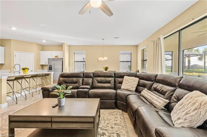 Living room featuring a wealth of natural light, recessed lighting, and ceiling fan with notable chandelier