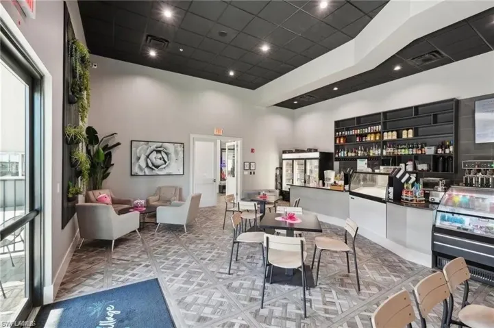 Dining space with baseboards, visible vents, a drop ceiling, and a towering ceiling