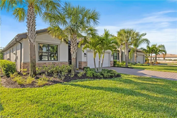 Ranch-style house featuring driveway, a garage, stucco siding, and a front yard