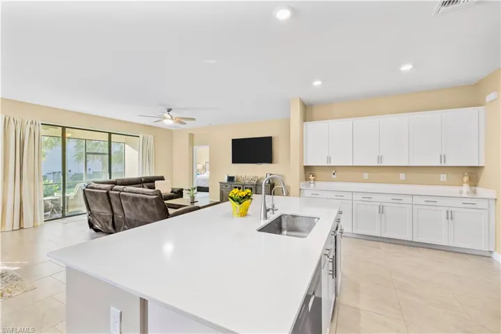 Kitchen with light tile patterned flooring, light countertops, visible vents, and a sink