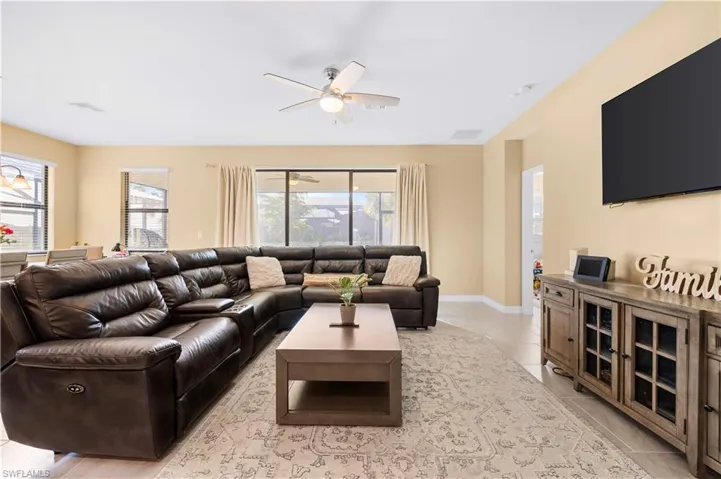 Living room with a wealth of natural light, visible vents, and ceiling fan