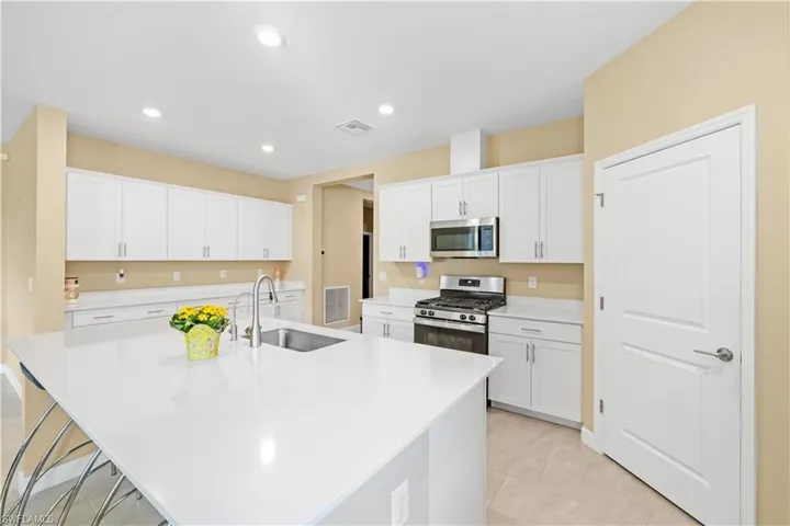 Kitchen with visible vents, white cabinets, appliances with stainless steel finishes, and a sink