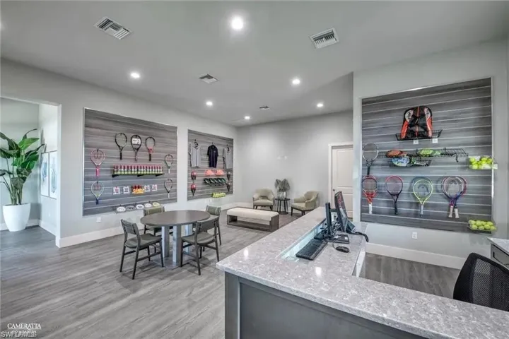 Kitchen featuring visible vents, recessed lighting, light stone counters, and wood finished floors