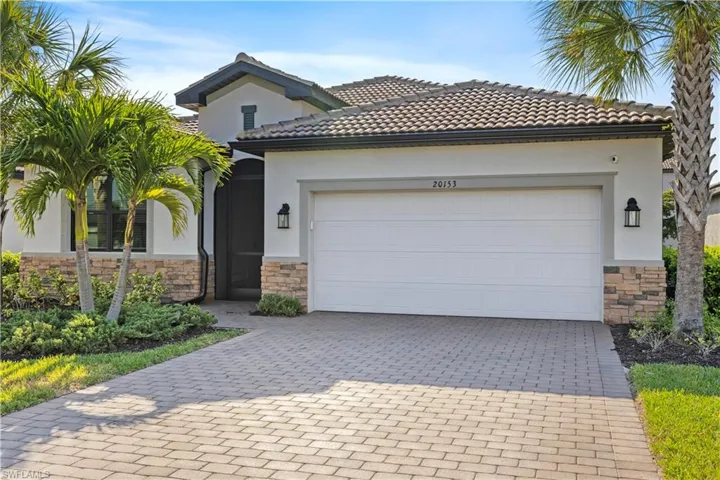 Mediterranean / spanish house featuring stucco siding, decorative driveway, and stone siding