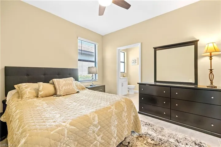 Bedroom featuring ensuite bath and ceiling fan