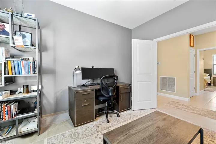 Office area featuring baseboards, visible vents, and tile patterned floors