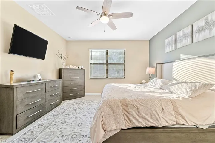 Bedroom with baseboards, a ceiling fan, and visible vents