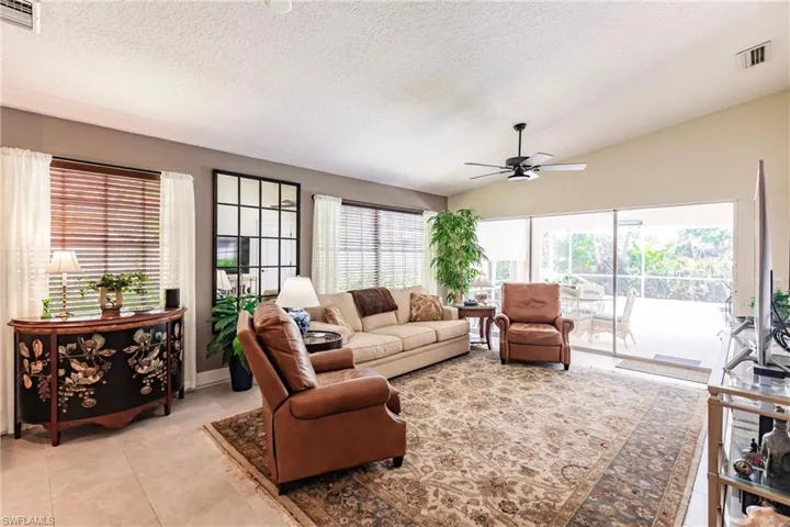 Living room featuring tile flooring, tons of natural light and views of the pool area.