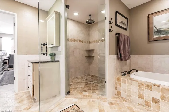 Remodeled Bathroom featuring tile floors and shower with separate bathtub