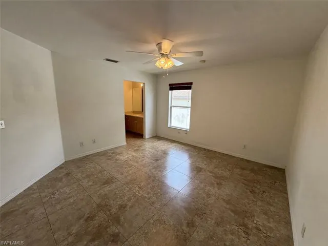 Spare room featuring ceiling fan and baseboards