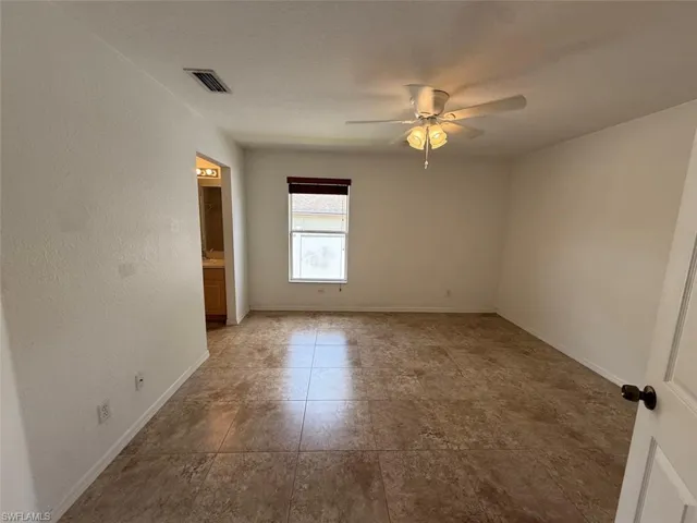 Spare room featuring ceiling fan and tile patterned flooring