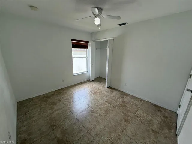 Unfurnished bedroom with a closet, ceiling fan, and tile patterned flooring