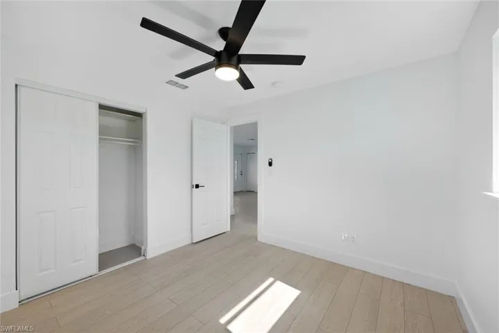 Unfurnished bedroom with ceiling fan, light hardwood / wood-style floors, and a closet