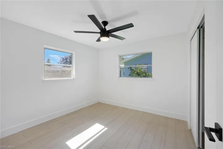 Empty room with light hardwood / wood-style floors, plenty of natural light, and ceiling fan