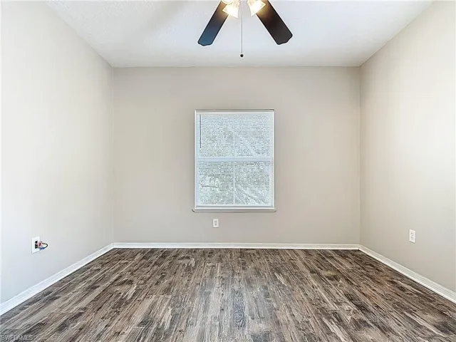 Spare room featuring dark wood-style floors, a ceiling fan, and a textured ceiling