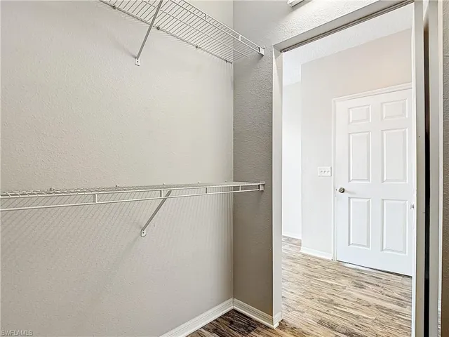 Walk in closet with light wood-style floors
