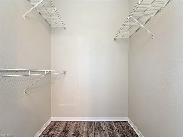 Walk in closet featuring dark wood finished floors