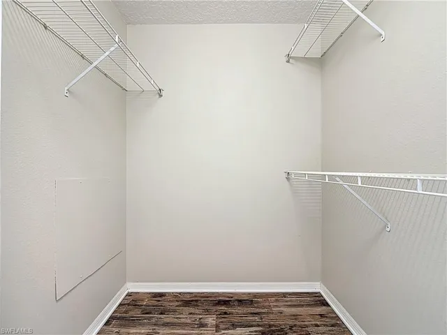 Walk in closet featuring dark wood-style floors