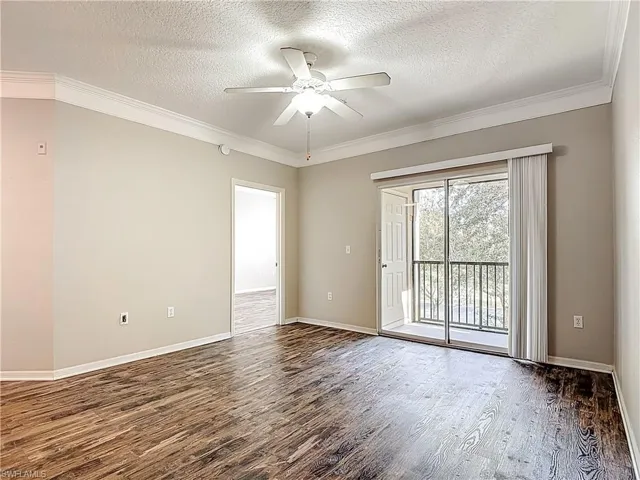 Unfurnished room with dark wood-style flooring, a textured ceiling, ornamental molding, and ceiling fan