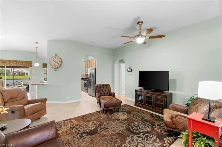 Living room with ceiling fan and light tile floors