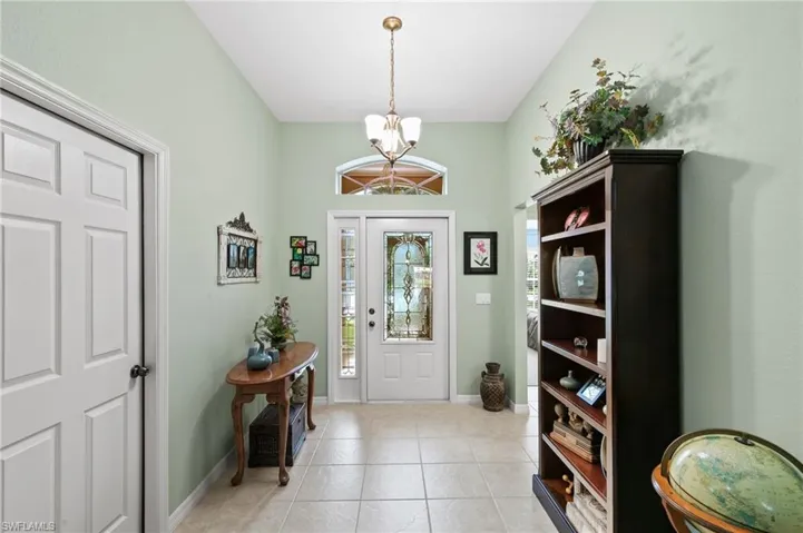 Foyer with light tile flooring and a chandelier
