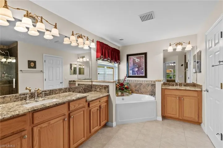 Bathroom with tile floors, independent shower and bath, and vanity