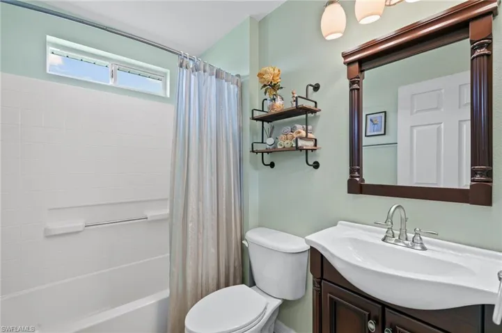 Full bathroom featuring vanity, toilet, and shower / bath combo with shower curtain