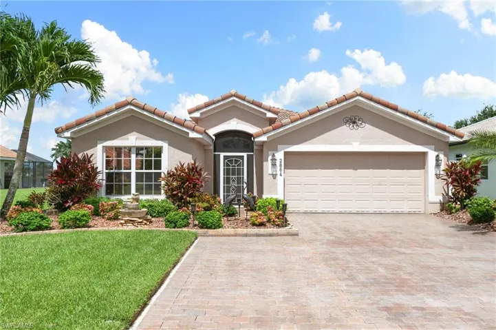 Mediterranean / spanish house with a garage and a front yard