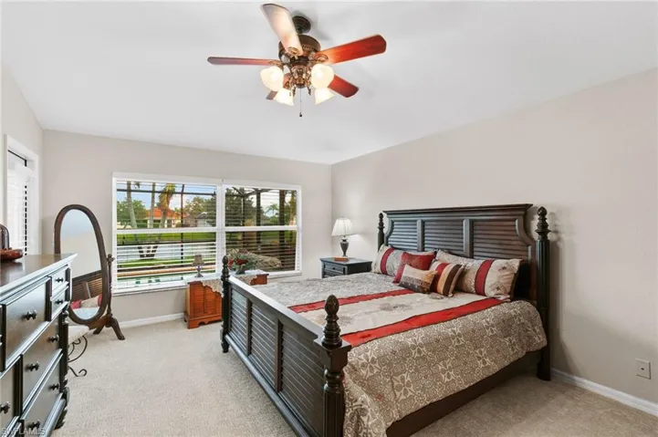 Bedroom with ceiling fan and light colored carpet