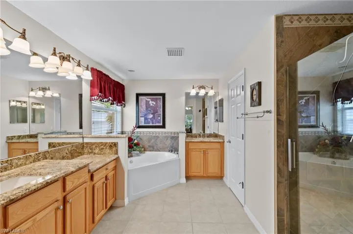 Bathroom featuring tile floors, vanity with extensive cabinet space, and plus walk in shower