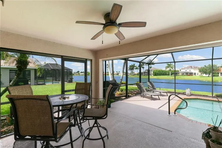 Sunroom / solarium with a water view and ceiling fan