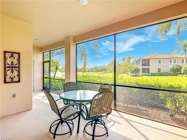 Expansive screened lanai with textured flooring, offering direct access to the outdoors