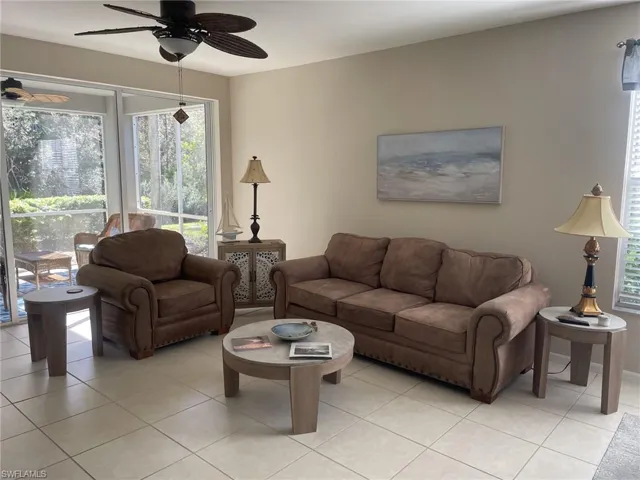 Living room with light tile patterned floors and a ceiling fan