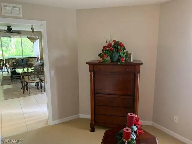 Hall with baseboards and light colored carpet