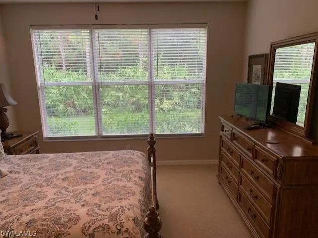 Bedroom with light colored carpet and baseboards