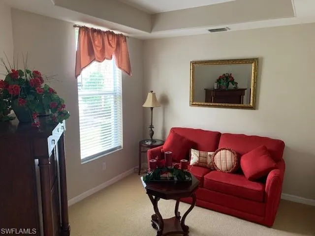 Carpeted living room featuring baseboards