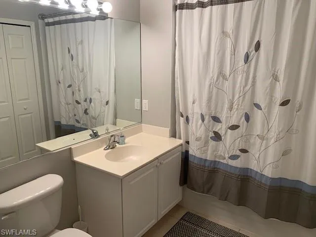 Full bath with vanity, tile patterned floors, and shower / tub combo with curtain