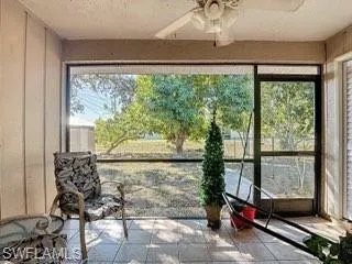 Sunroom / solarium with tile patterned flooring and a textured ceiling