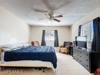 Bedroom featuring ceiling fan and a textured ceiling