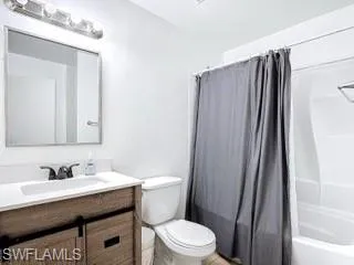 Bathroom featuring vanity and shower / bath combination with curtain