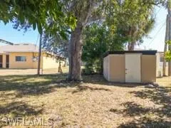 View of grassy yard featuring a storage unit