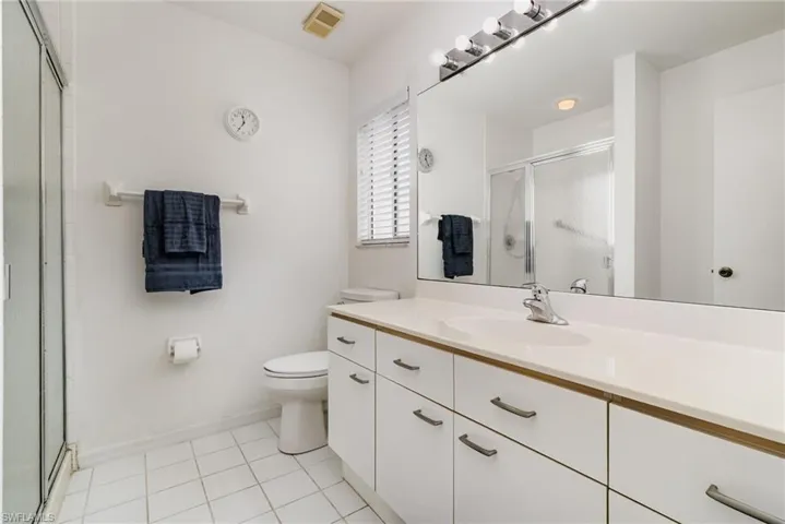 Primary Bathroom with vanity, a stall shower, and light tile patterned flooring