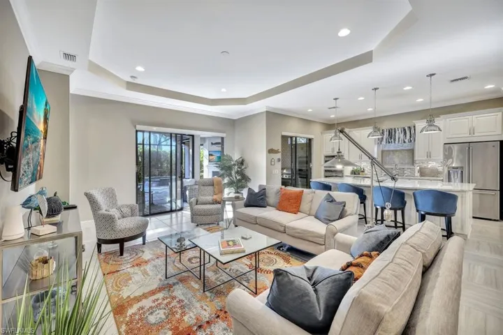 Tiled living room featuring a tray ceiling and crown molding