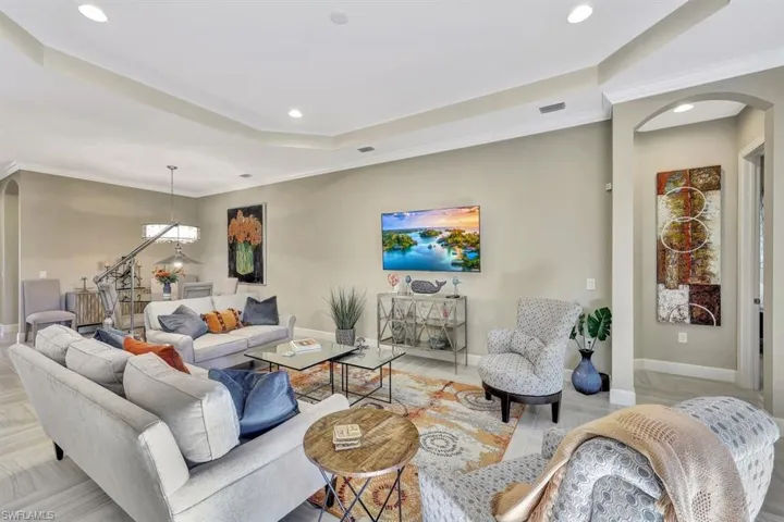 Living room featuring a raised ceiling and crown molding