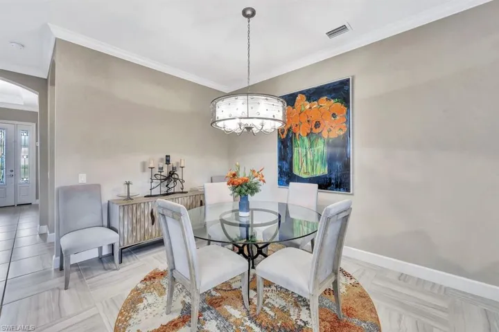 Dining area featuring crown molding and a notable chandelier