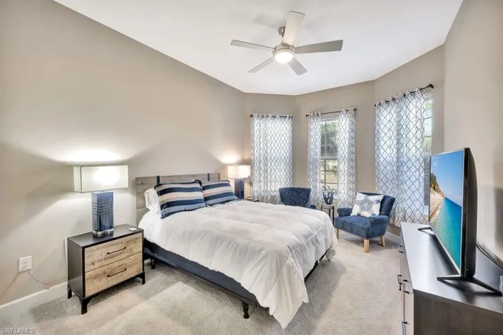 Carpeted bedroom featuring ceiling fan