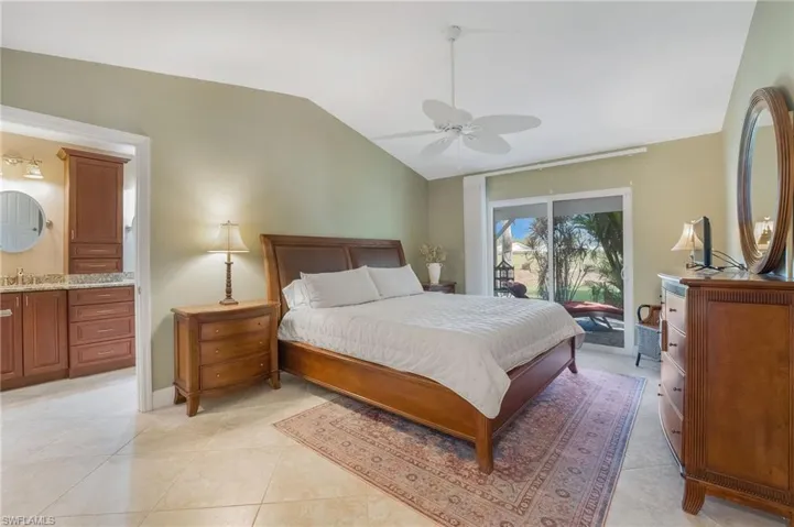The primary bedroom offers direct access to a screened lanai, ideal for watching golfers or enjoying a good book, and features a vaulted ceiling and a full ensuite bath.