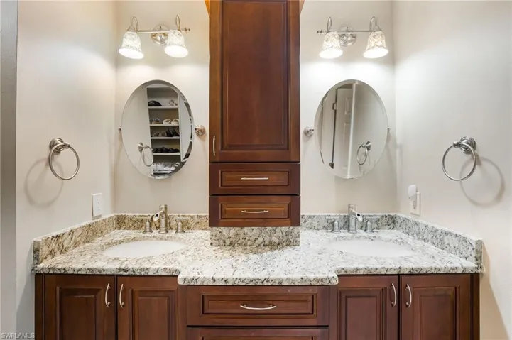 The primary bath features dual granite-topped vanities and custom cabinetry.