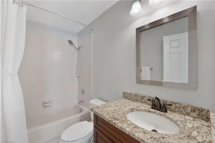 The second bathroom features a shower/tub combination and a granite-topped vanity.