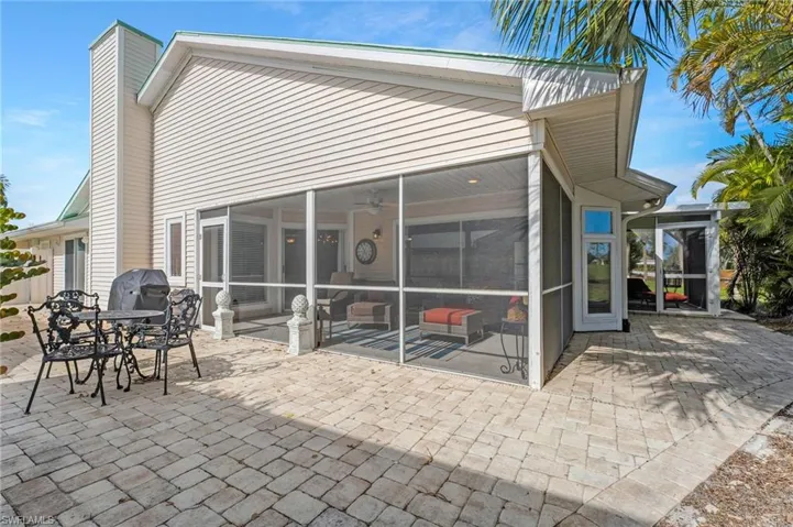 A sun-soaked screened lanai and expansive pavered patio provide the perfect setting for entertaining or enjoying the action on the golf course.